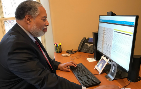 Smithsonian Secretary Lonnie G. Bunch III at his desk transcribing a page in Transcription Center.